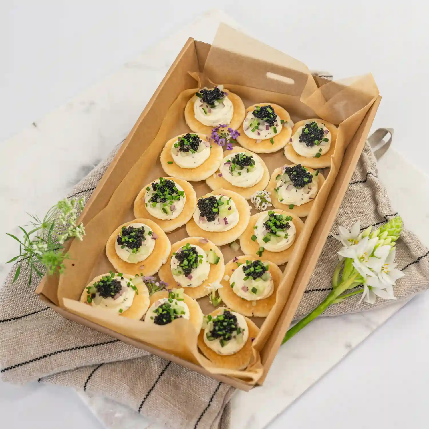 Blini, crème fraîche, petite black caviar pearls, chive