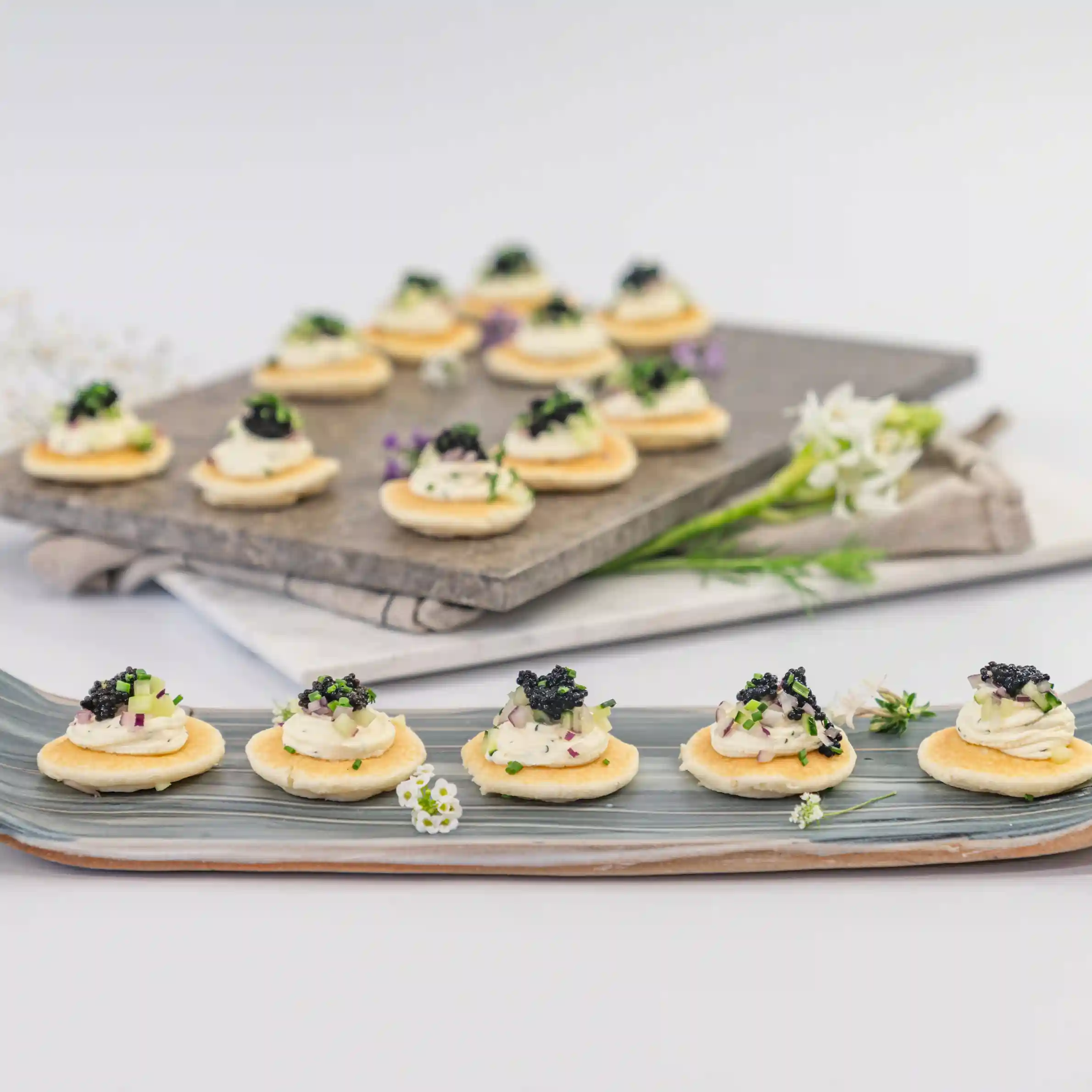 Blini, crème fraîche, petite black caviar pearls, chive