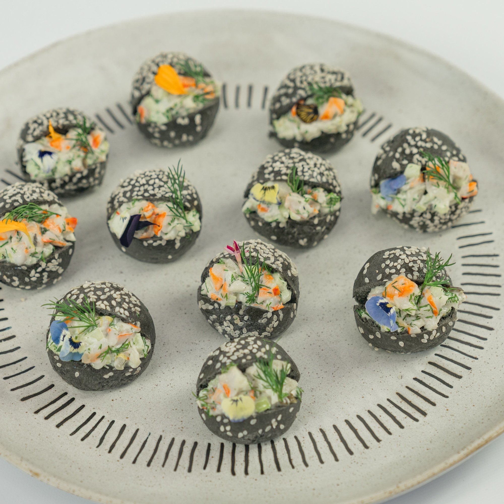Australian prawn, citrus and dill remoulade, charcoal brioche baby bun, edible blooms