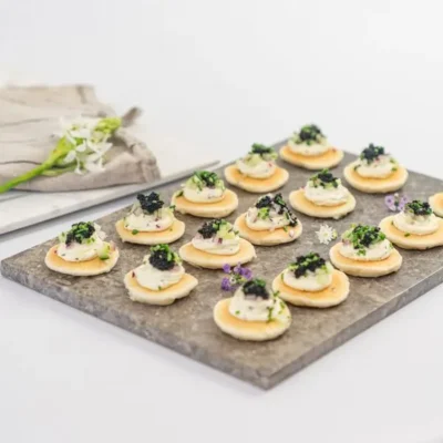 Blini, crème fraîche, petite black caviar pearls, chive