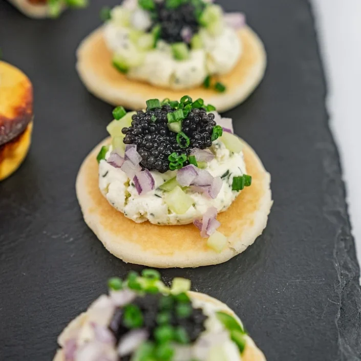 Blini, crème fraîche, petite black caviar pearls, chive