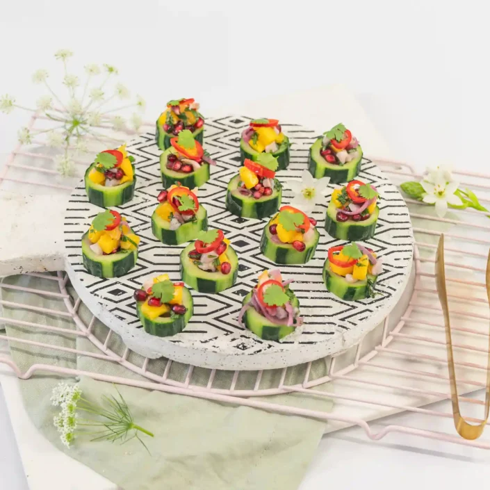 Mango, lychee & pomegranate salsa on cucumber disc with pickled chilli