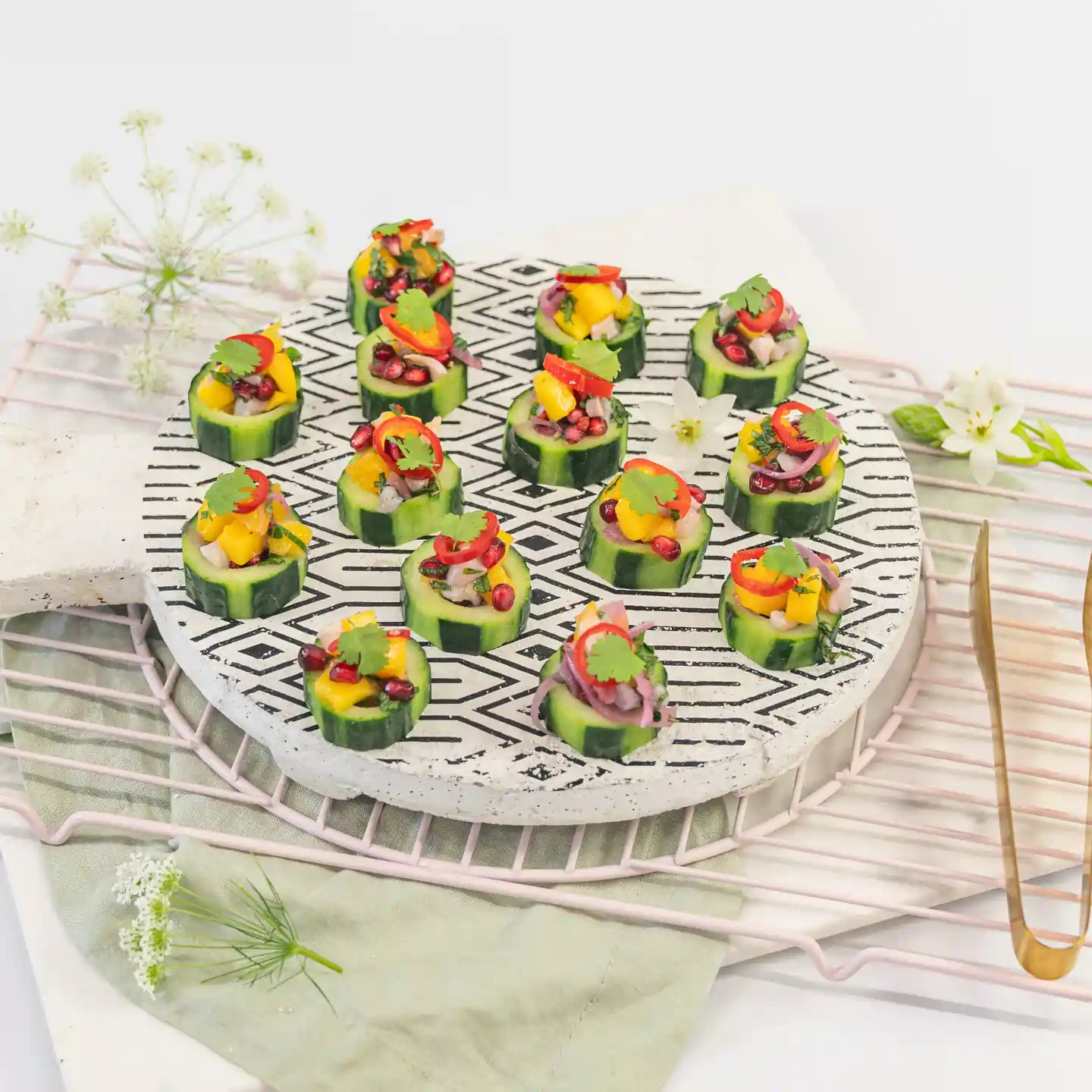 Mango, lychee & pomegranate salsa on cucumber disc with pickled chilli